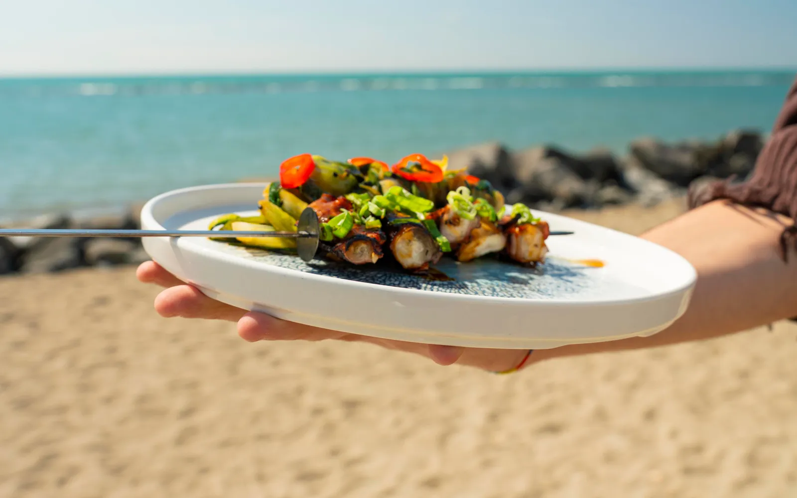 Piatto gourmet del Capanno Beach Club servito in riva al mare, a Ostia